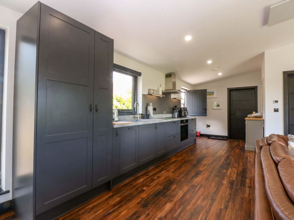 A kitchen with cabinets, sink, and appliances at Y Cwt in Moelfre