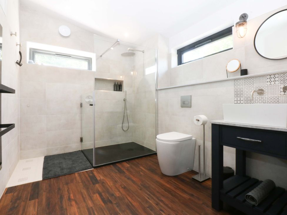 A bathroom with shower, toilet, and sink at Y Cwt in Moelfre