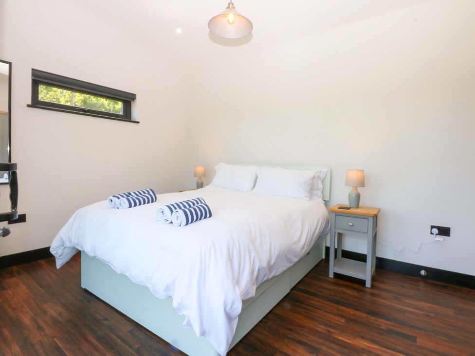 A bedroom with a bed and nightstand at Y Cwt in Moelfre