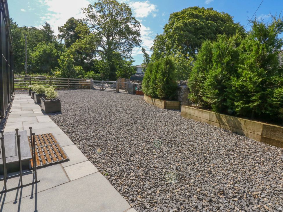 A garden with gravel and planters at Y Cwt in Moelfre