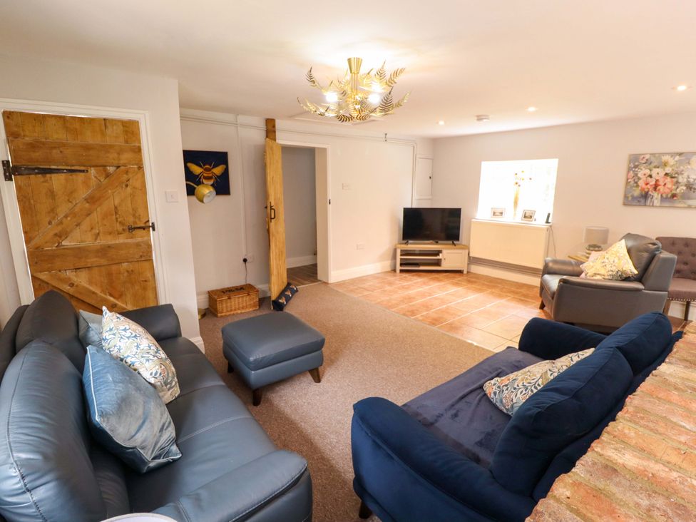 A living room with sofas and a television at Wood Farm Cottage Stickney near East Kirkby