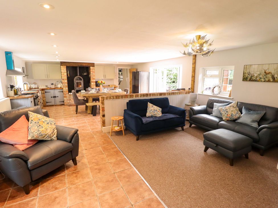 A living room with sofas and a kitchen area at Wood Farm Cottage Stickney near East Kirkby