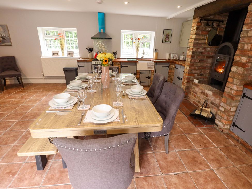 A dining room with a large table set for meals at Wood Farm Cottage Stickney near East Kirkby