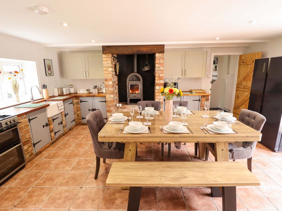 A kitchen with a dining table set for a meal at Wood Farm Cottage in Stickney near East Kirkby