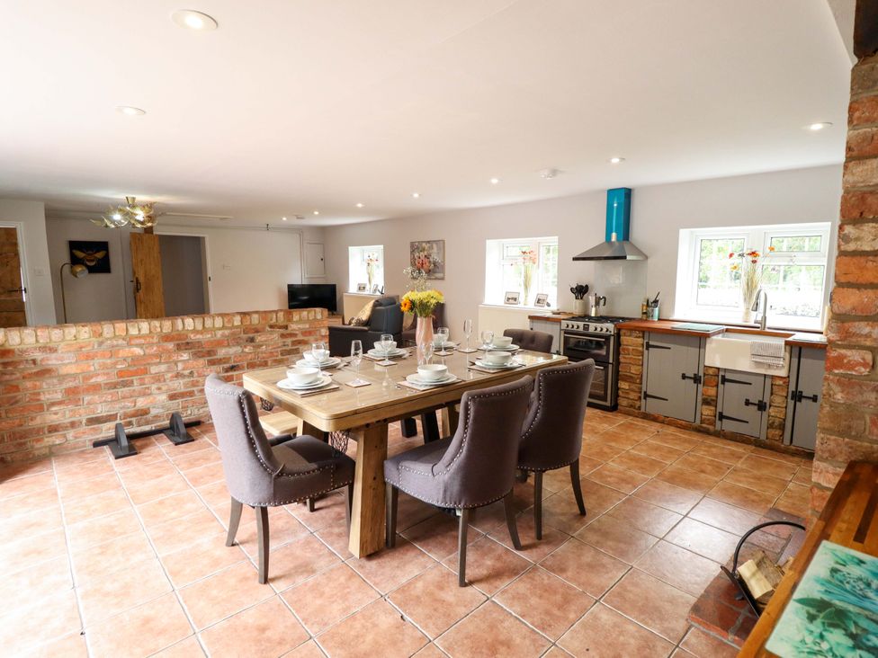 A dining room with a table set for meals at Wood Farm Cottage in Stickney near East Kirkby