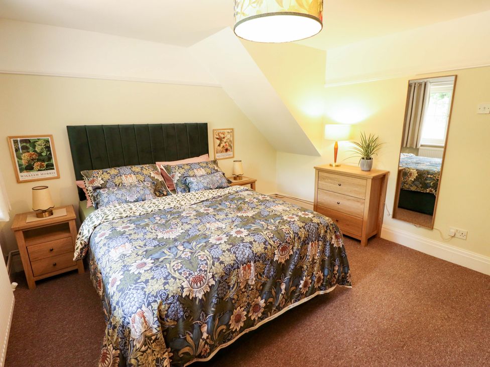 A bedroom with a bed and dresser at Wood Farm Cottage in Stickney near East Kirkby