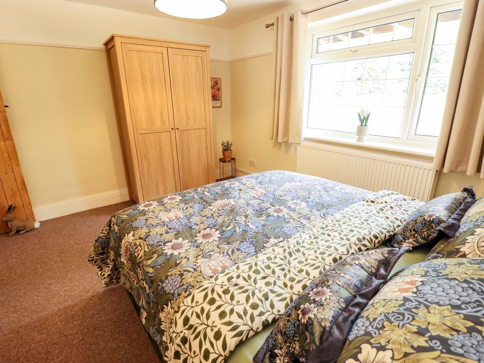 A bedroom with a bed and wardrobe at Wood Farm Cottage Stickney near East Kirkby