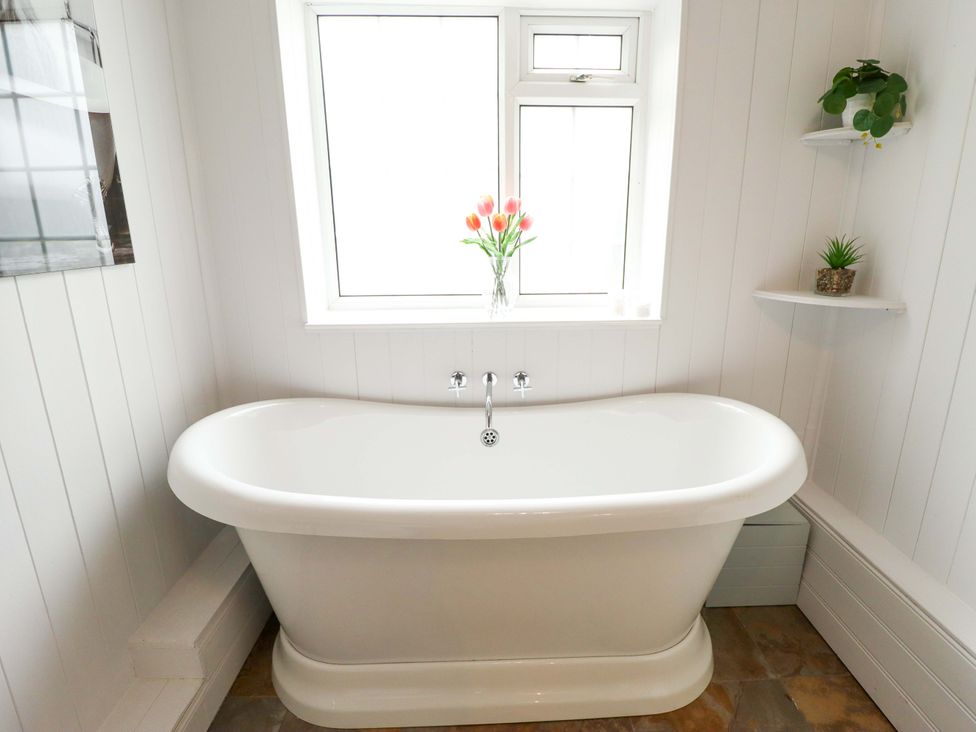 A bathroom with a bathtub and a window at Wood Farm Cottage Stickney near East Kirkby