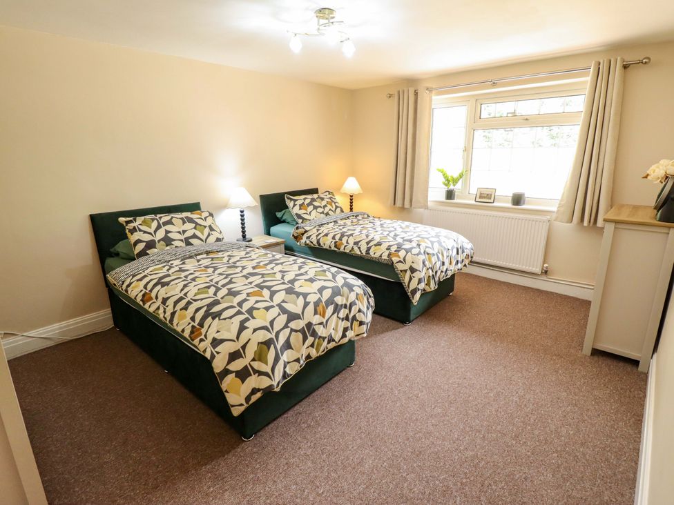 A bedroom with two beds and a window at Wood Farm Cottage Stickney near East Kirkby