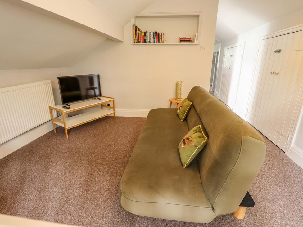 A living room with a sofa and television at Wood Farm Cottage in Stickney near East Kirkby