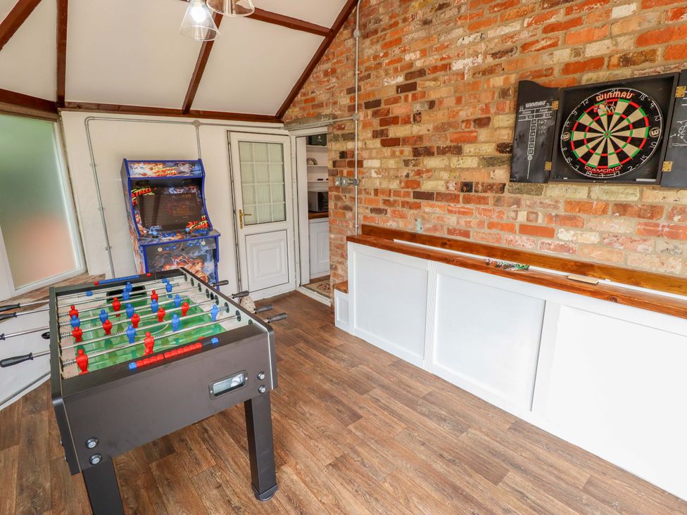 A snug with a foosball table and dartboard at Wood Farm Cottage in Stickney near East Kirkby