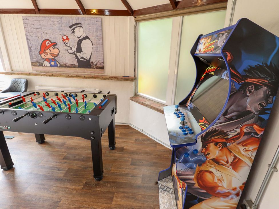 A game room with a foosball table and arcade machine at Wood Farm Cottage Stickney near East Kirkby