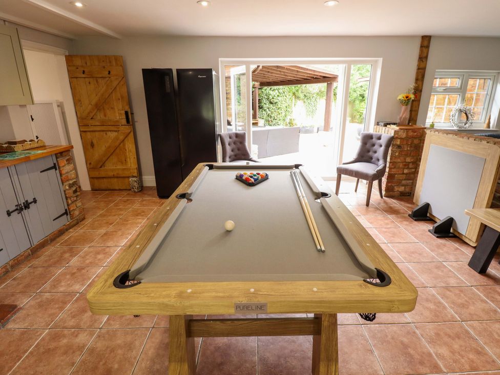 A game room with a pool table and chairs at Wood Farm Cottage in Stickney near East Kirkby