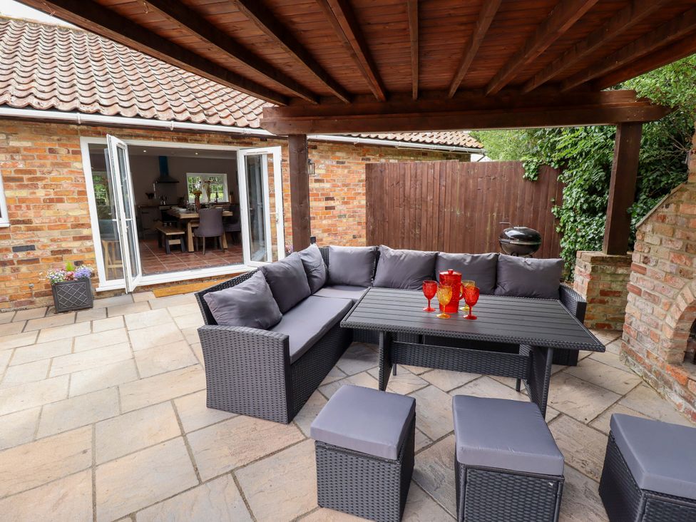 An outdoor seating area with a table and fire pit at Wood Farm Cottage Stickney near East Kirkby