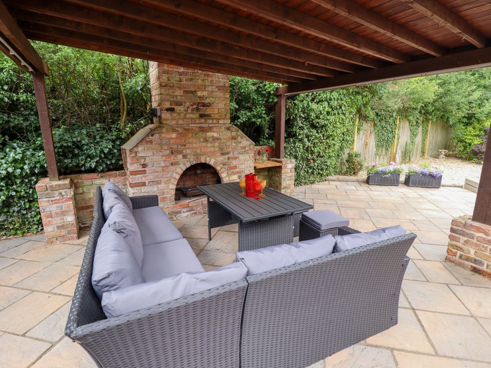 An outdoor seating area with sofa and fireplace at Wood Farm Cottage in Stickney near East Kirkby