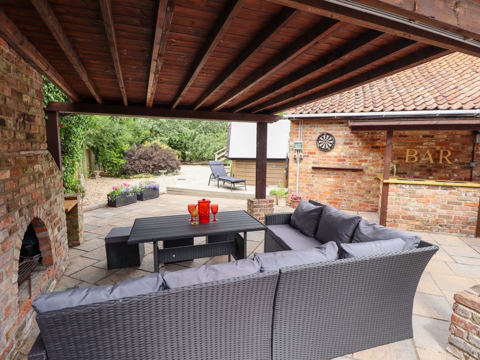 An outdoor seating area with a sofa and a bar at Wood Farm Cottage Stickney near East Kirkby