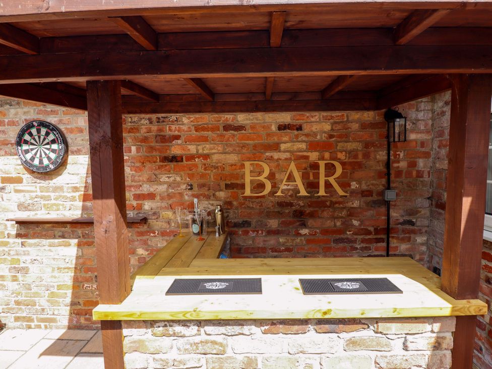 An outdoor bar with a counter and darts board at Wood Farm Cottage Stickney near East Kirkby