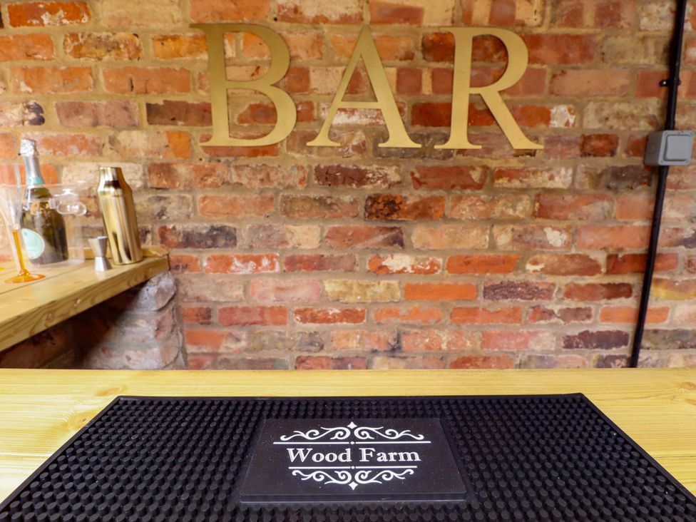 A bar with a wooden countertop and various barware at Wood Farm Cottage Stickney near East Kirkby