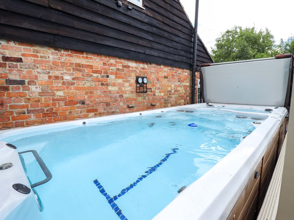 A hot tub with water and mechanical gauges at Wood Farm Cottage Stickney near East Kirkby
