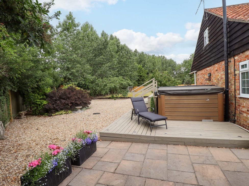 A garden with a hot tub and lounge chair at Wood Farm Cottage Stickney near East Kirkby