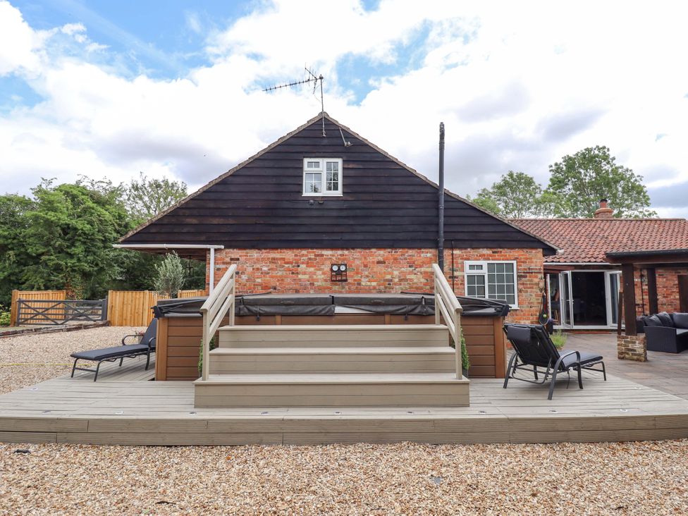 A house with a deck and chairs at Wood Farm Cottage Stickney near East Kirkby