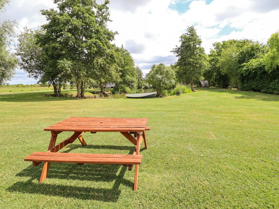 A picnic table on grass near a pond at Wood Farm Cottage Stickney near East Kirkby