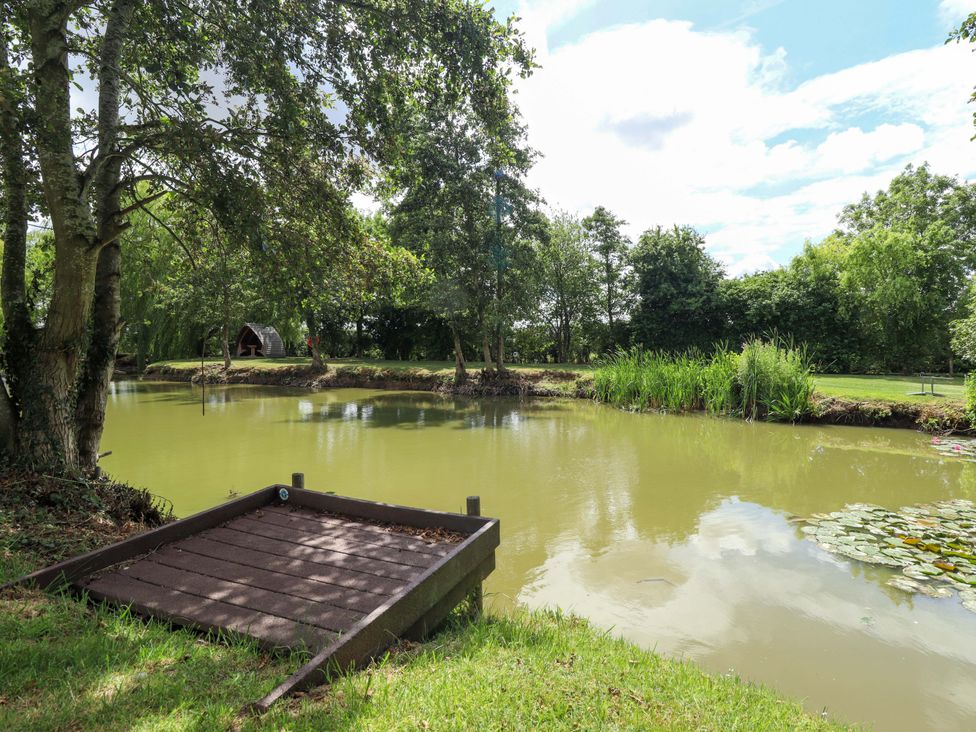 A pond with a wooden platform at Wood Farm Cottage Stickney near East Kirkby