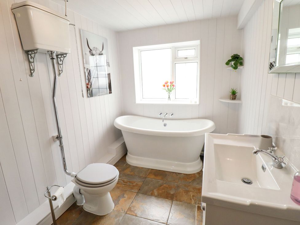 A bathroom with a bath tub, toilet, and sink at Wood Farm Cottage Stickney near East Kirkby