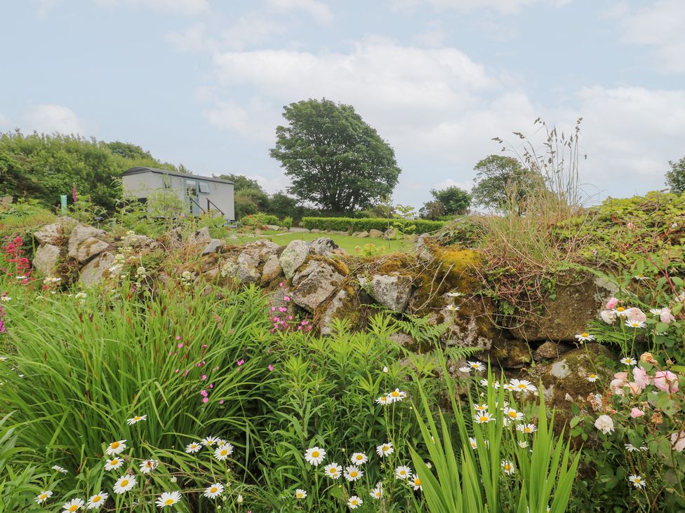 A garden with flowers and a stone wall at Teg in Prospidnick near Porthleven