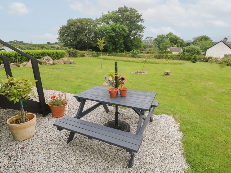 A garden with a picnic table and flower pots at Teg in Prospidnick near Porthleven