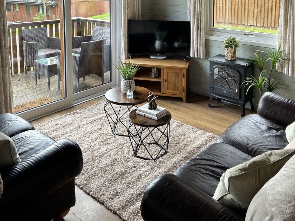 A living room with a sofa, coffee table, and television at Number 39 Bodmin