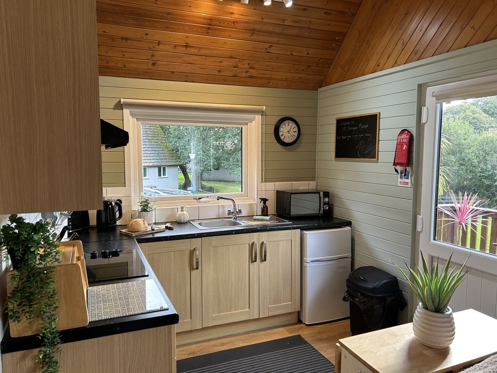 A kitchen with a window and appliances at Number 39 Bodmin