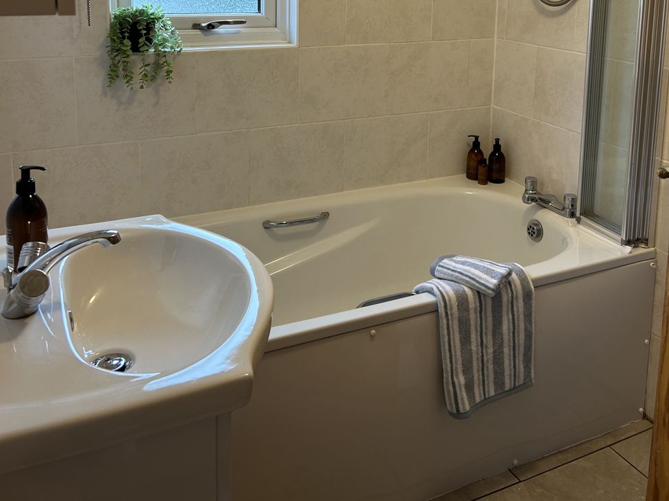 A bathroom with a bathtub and sink at Number 39 Bodmin