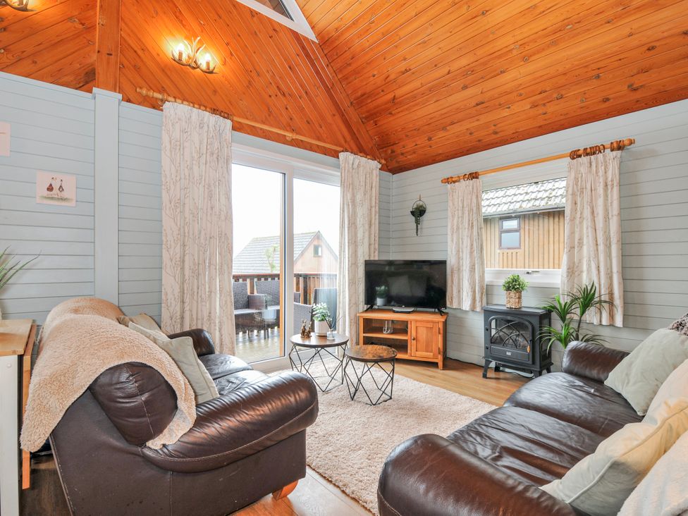 A living room with a sofa and coffee table at Cornish Woodland Retreat Near St Tudy