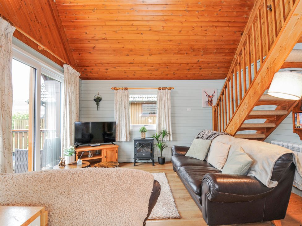 A living room with a sofa and television at Cornish Woodland Retreat Near St Tudy