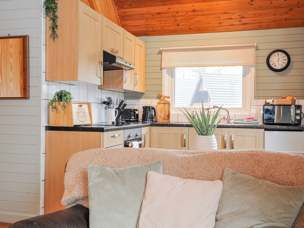 A kitchen with cabinets and appliances at Cornish Woodland Retreat Near St Tudy