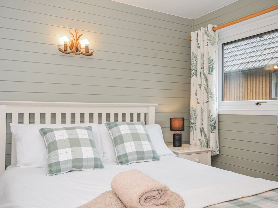 A bedroom with a bed and window at Cornish Woodland Retreat Near St Tudy