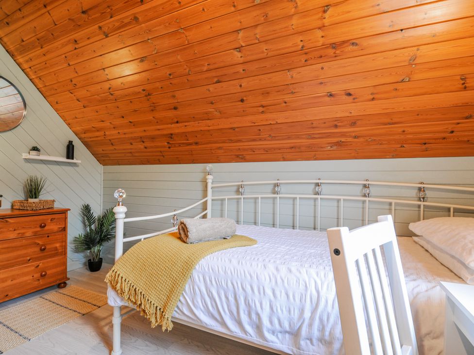 A bedroom with a bed and dresser at Cornish Woodland Retreat Near St Tudy