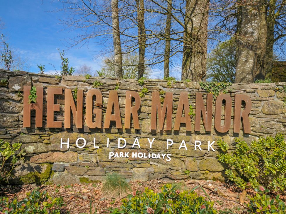 A sign for Hengar Manor Holiday Park surrounded by greenery near St Tudy