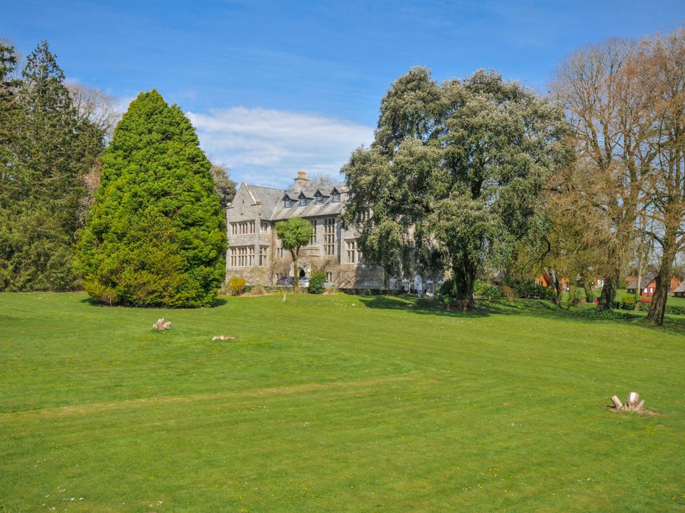 An outdoor area with a building and trees at Cornish Woodland Retreat Near St Tudy