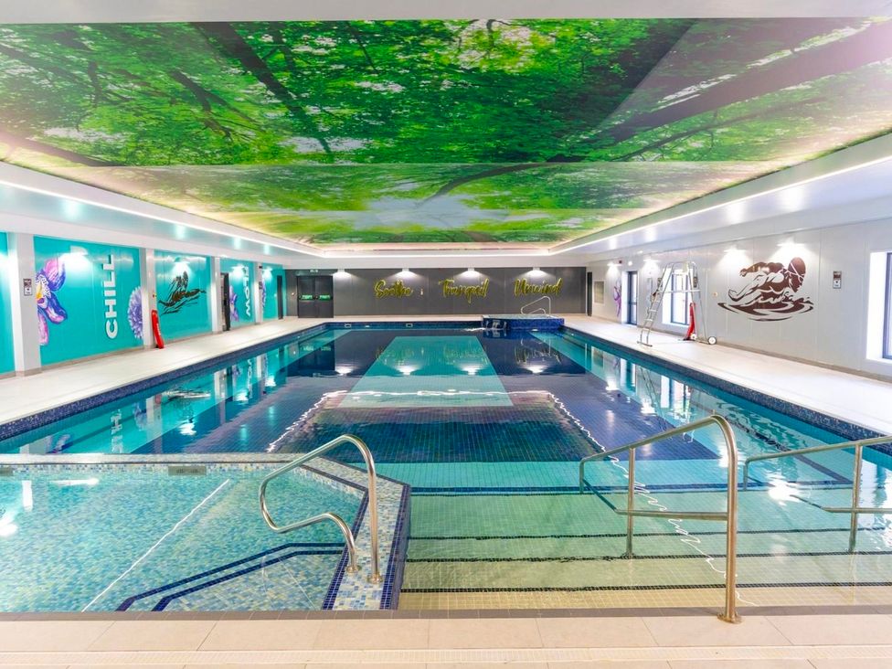 An indoor swimming pool with a ceiling mural at Cornish Woodland Retreat Near St Tudy