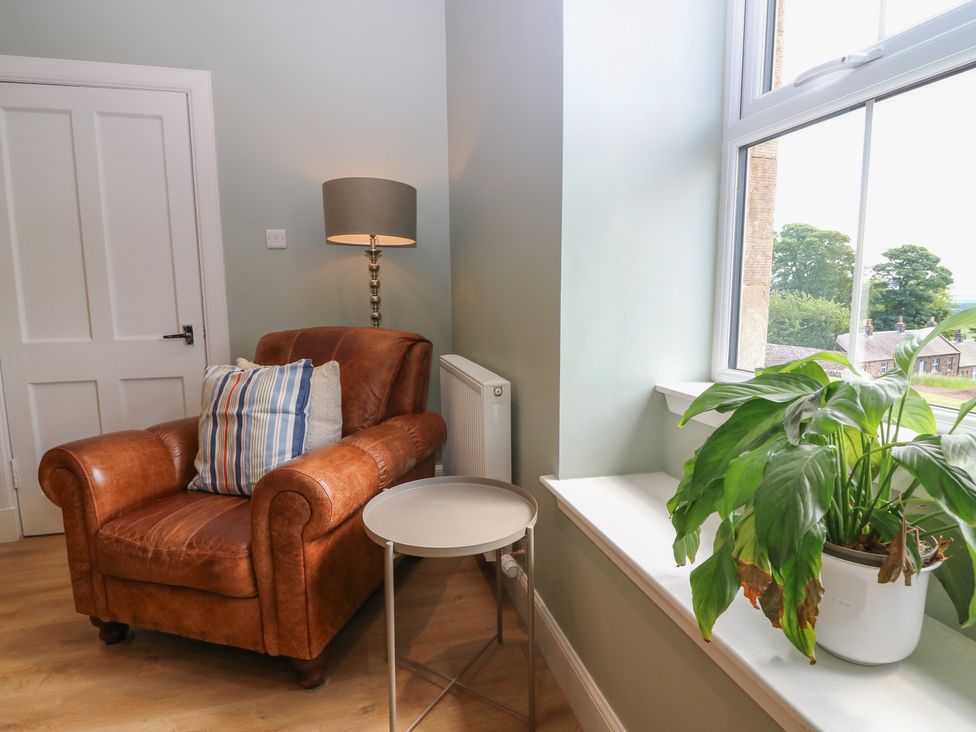 A living room with an armchair and a lamp at No 6 - 2 bed Haddington