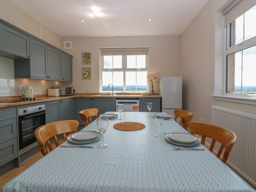 A kitchen with a dining table and appliances at No 6 - 2 bed Haddington