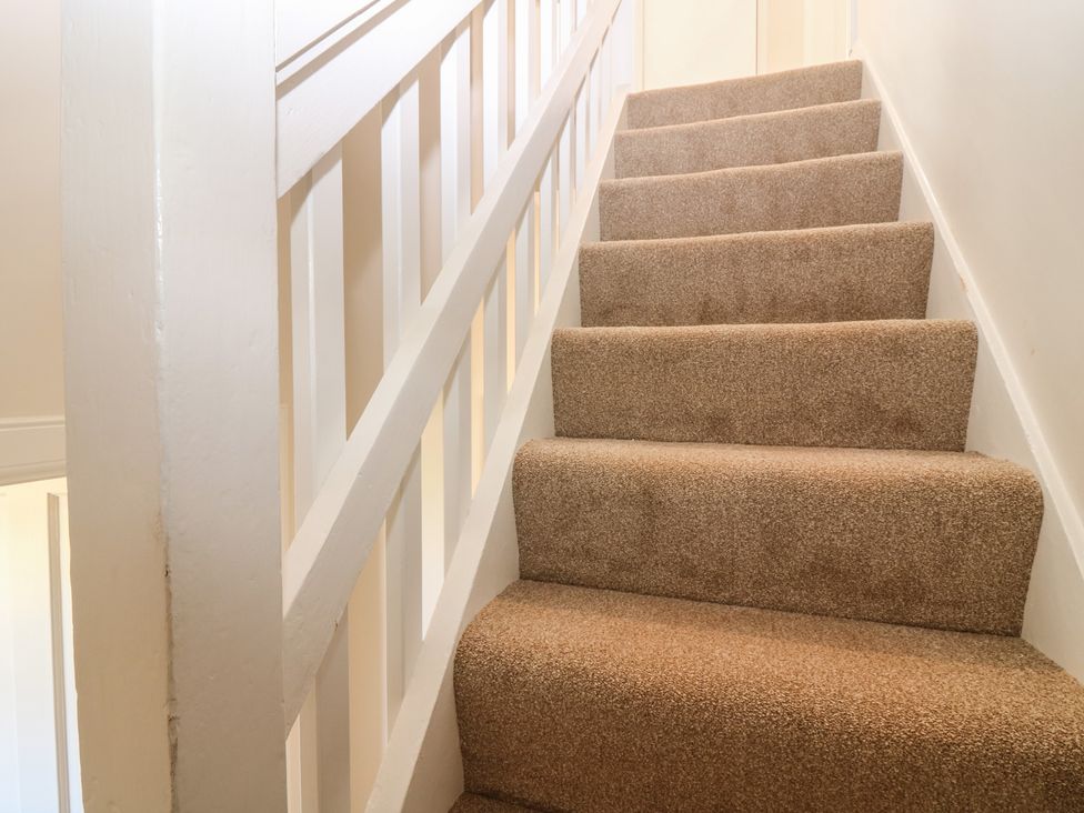 A staircase with carpet and a banister at No 6 - 2 bed Haddington