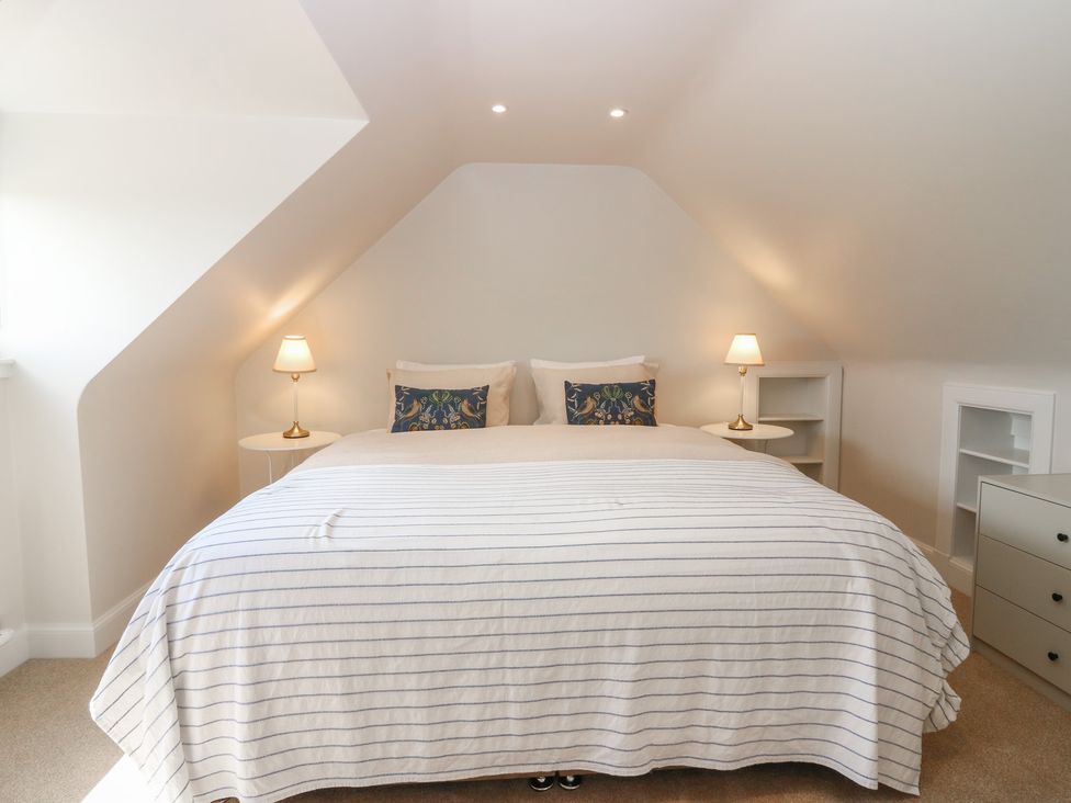 A bedroom with a bed, lamps, and shelves at No 6 - 2 bed Haddington