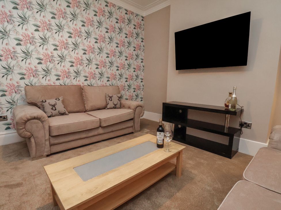 A living room with a sofa and a television at 11 Rutland Street in Filey