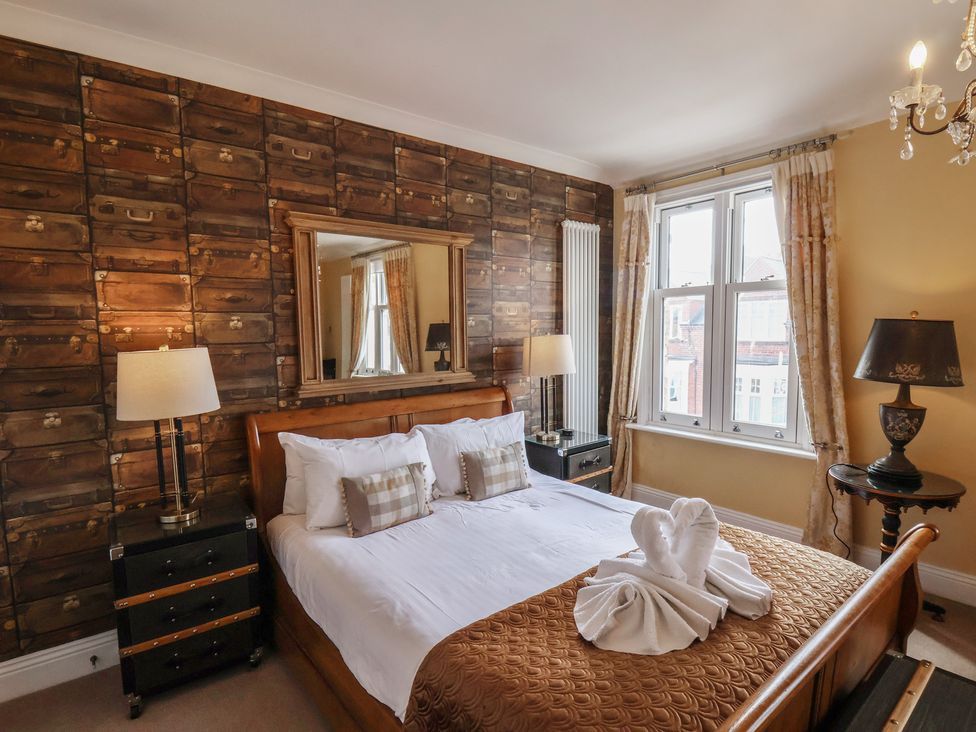 A bedroom with a bed and mirror at 11 Rutland Street Filey