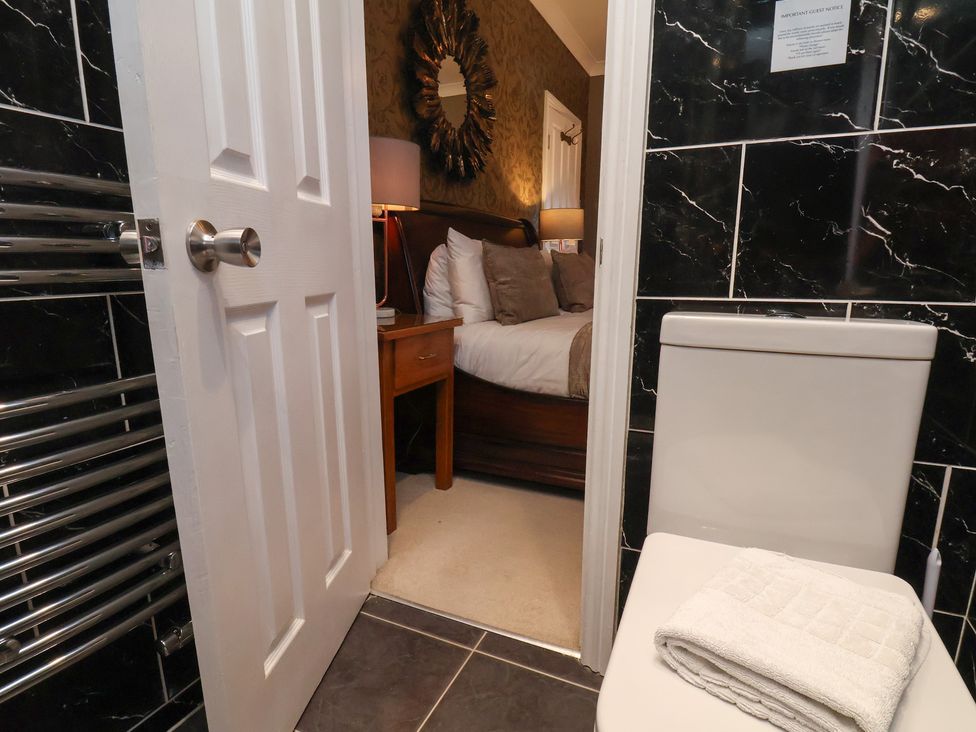 A bathroom with a toilet and a view of a bedroom at 11 Rutland Street in Filey