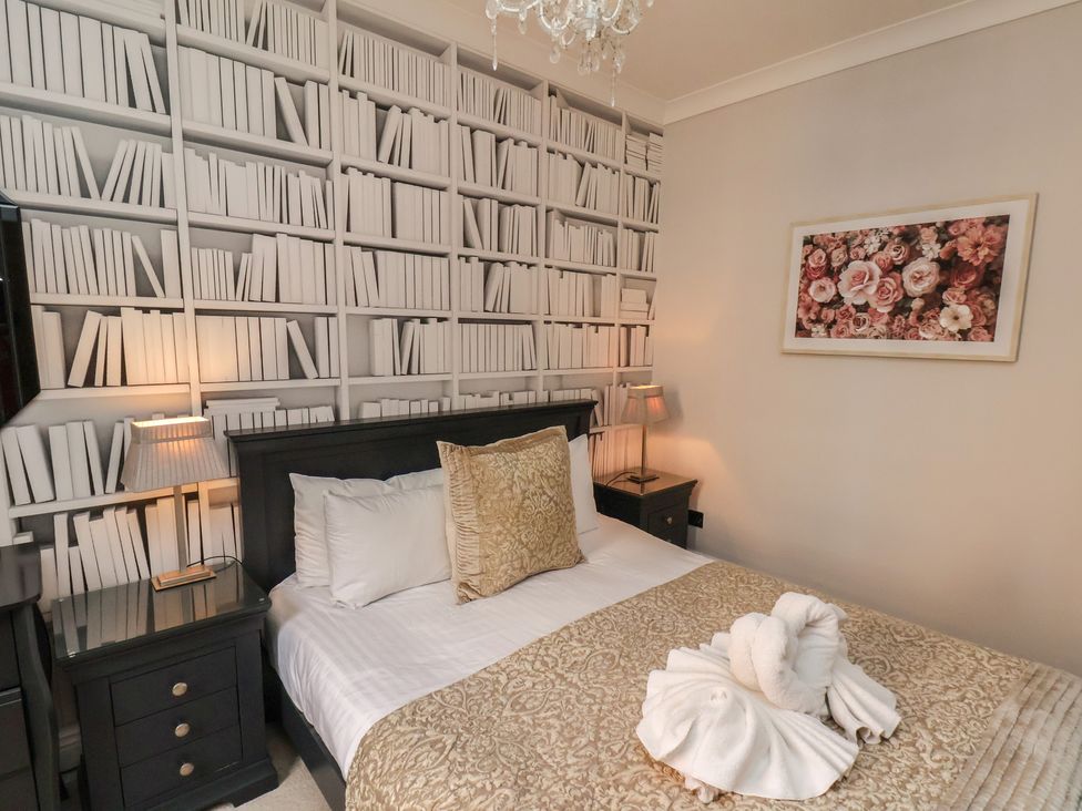 A bedroom with a bed and bookshelf wall at 11 Rutland Street, Filey