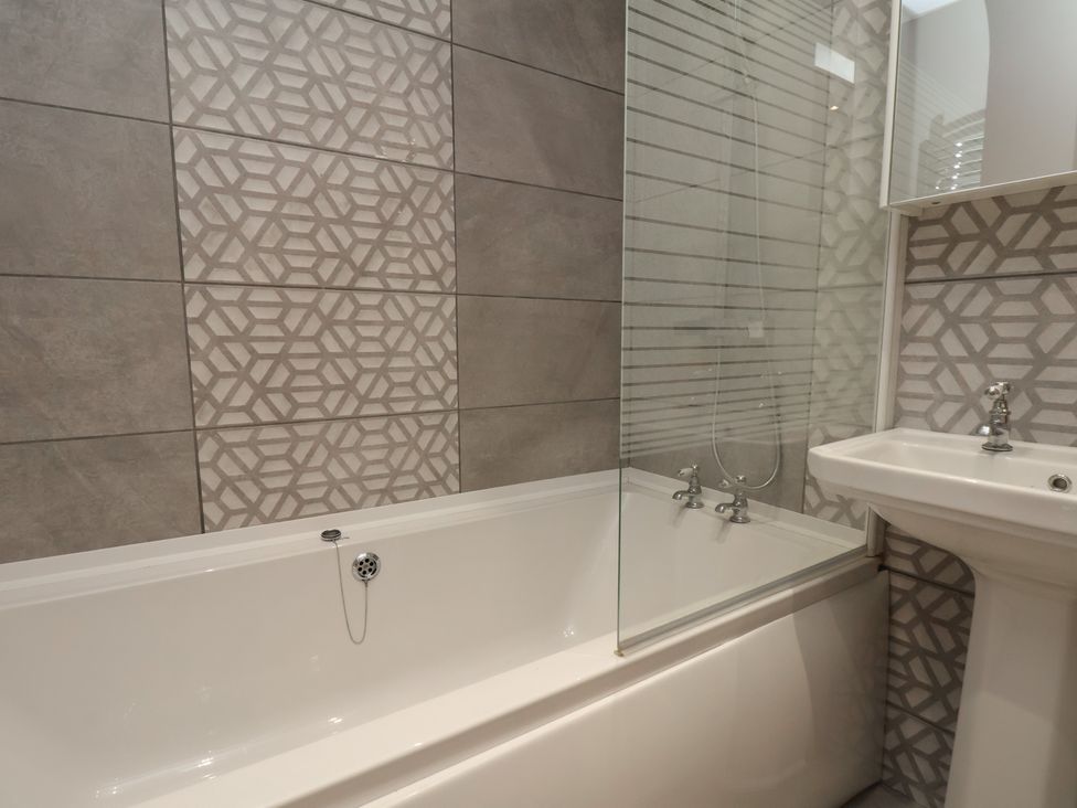 A bathroom with a bathtub and sink at 11 Rutland Street in Filey